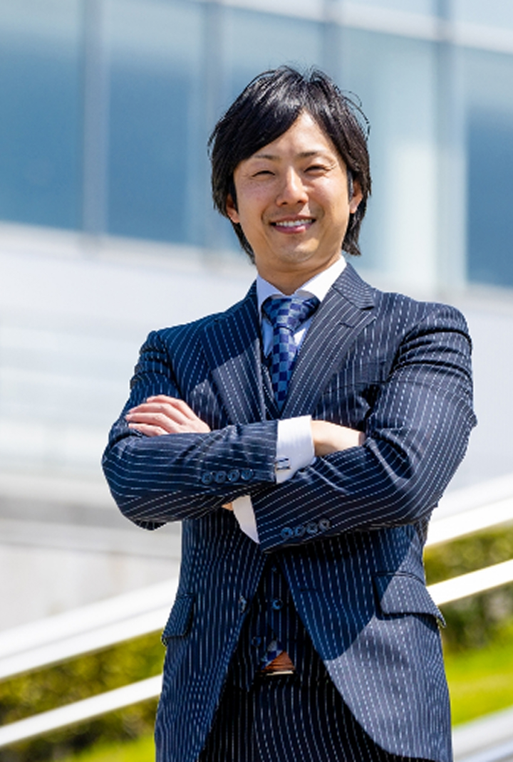 会社代表が外で腕を組んで笑顔の写真